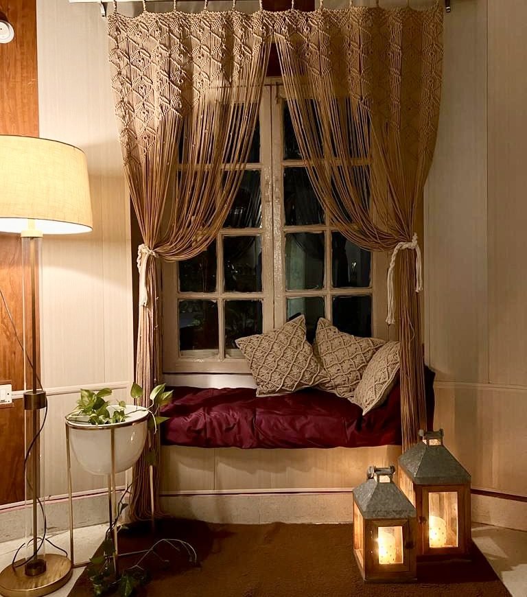 Macramé window nook curtains with cushions and lanterns